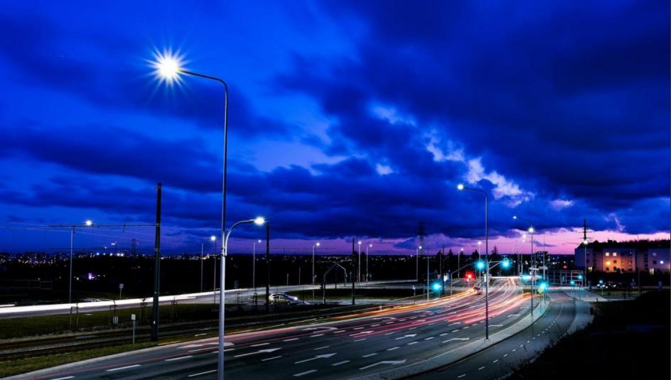 City street with heavy traffic under a cloudy dusk sky
