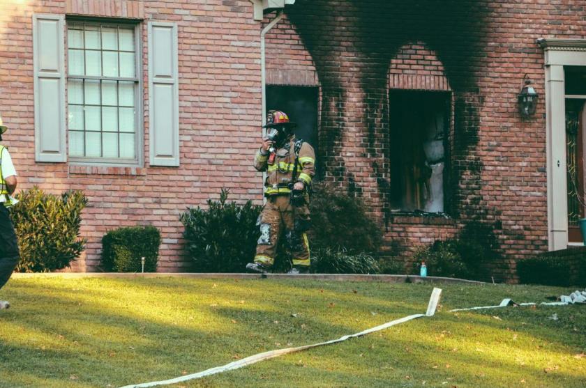 Fireman walking away from a brick house