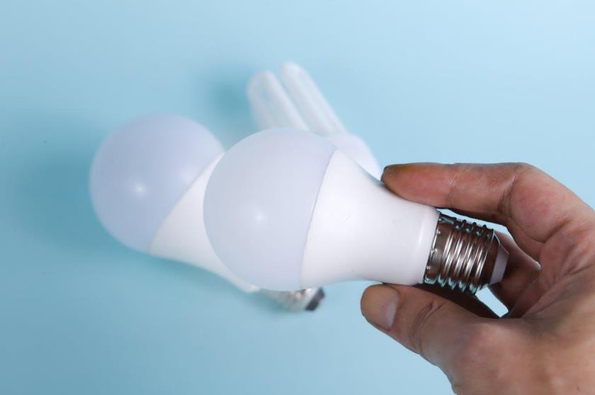 Person holding a white LED light bulb