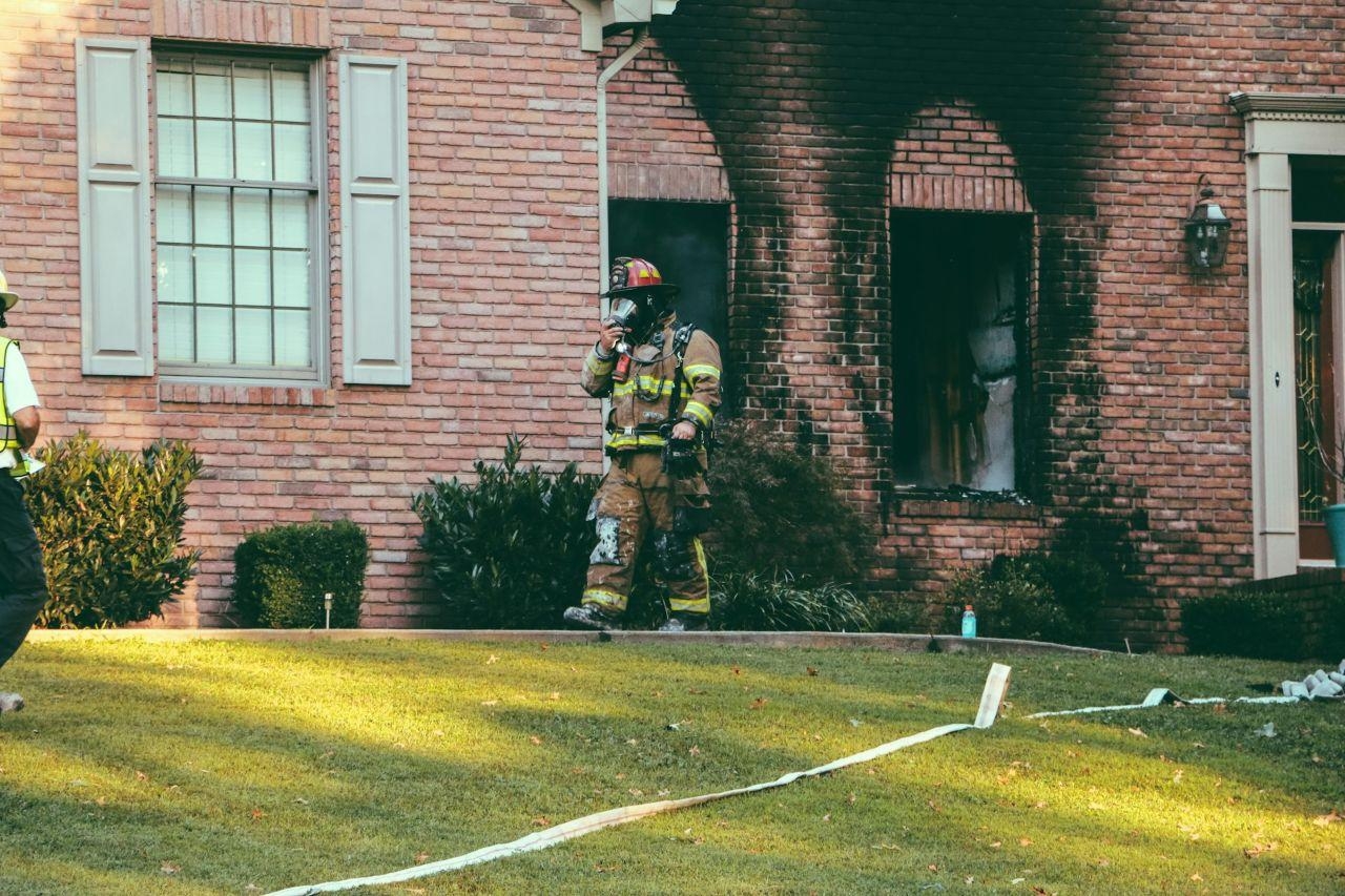 Fireman walking away from a brick house