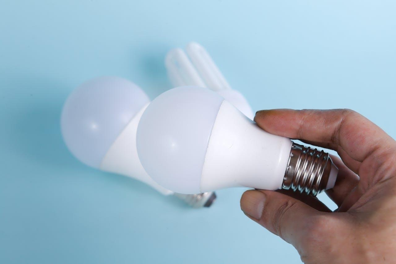 Person holding a white LED light bulb